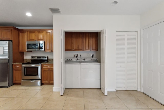 kitchen featuring light tile patterned flooring, visible vents, washer and dryer, and appliances with stainless steel finishes