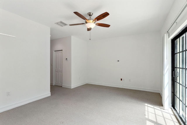 spare room with visible vents, light carpet, baseboards, and ceiling fan