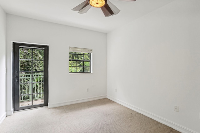 empty room with baseboards, light carpet, and a ceiling fan