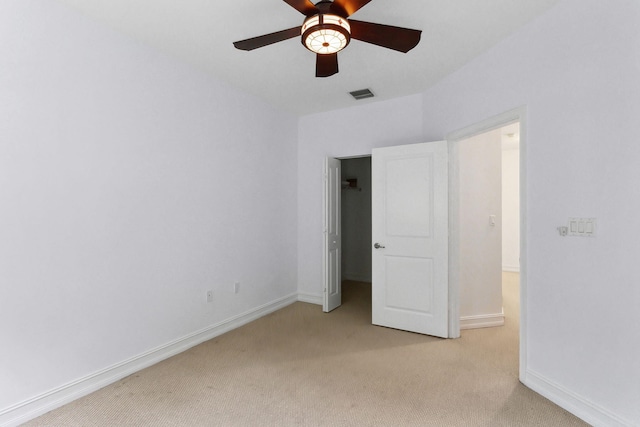 unfurnished bedroom featuring light carpet, visible vents, a ceiling fan, and baseboards