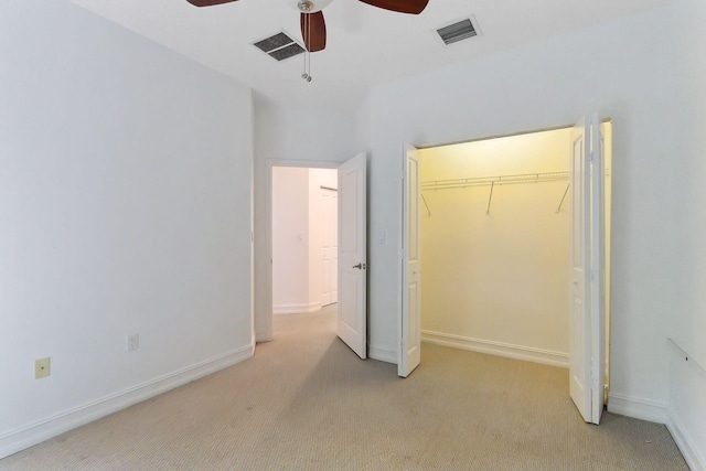 unfurnished bedroom with light colored carpet, visible vents, a closet, and baseboards