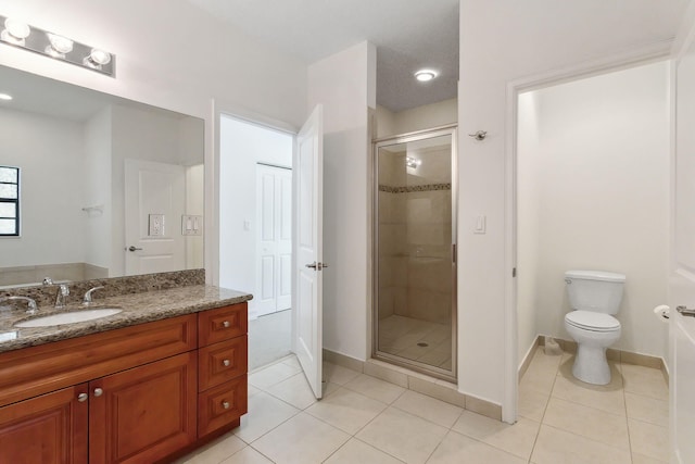 full bath with a shower stall, baseboards, toilet, tile patterned floors, and vanity