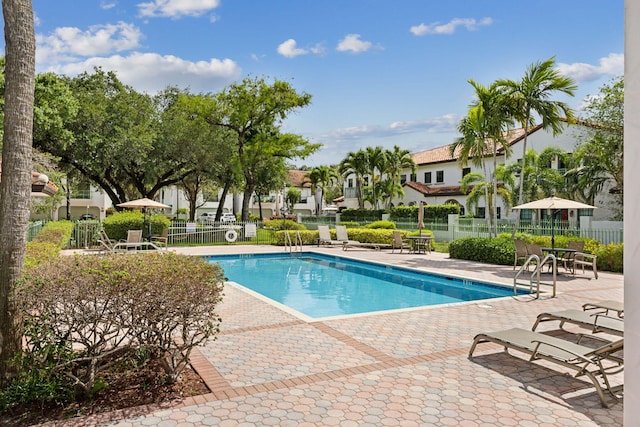 community pool featuring a patio area and fence