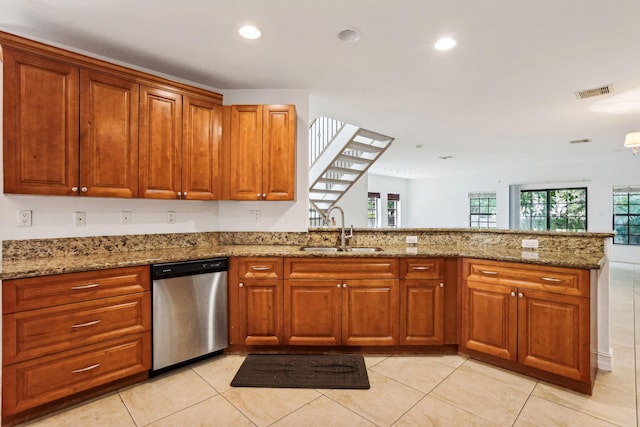 kitchen with kitchen peninsula, dishwasher, light stone countertops, light tile patterned floors, and sink