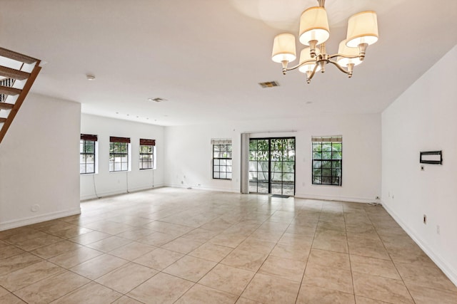 unfurnished room with an inviting chandelier, light tile patterned floors, baseboards, and visible vents