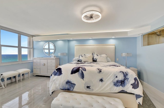 bedroom featuring light hardwood / wood-style flooring and a water view