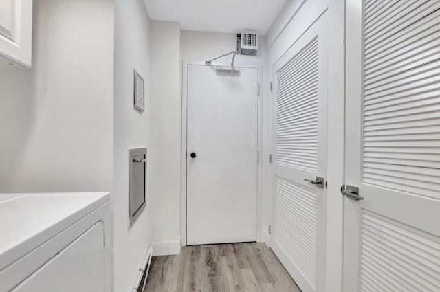 bathroom with hardwood / wood-style flooring and washer / dryer