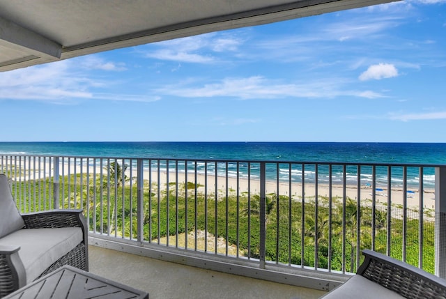 balcony featuring a water view and a beach view