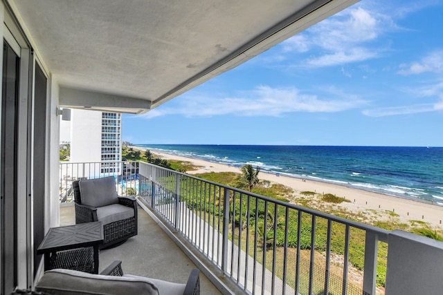 balcony featuring a water view, a beach view, and outdoor lounge area