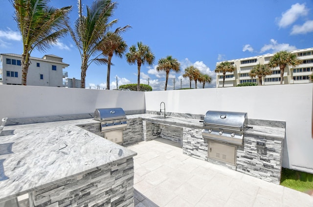 view of patio with grilling area, sink, and an outdoor kitchen