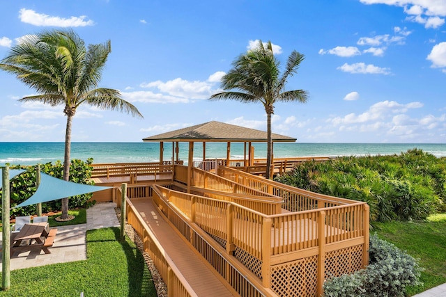 exterior space with a patio area, a water view, and a view of the beach