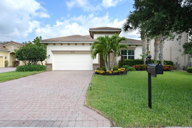 mediterranean / spanish-style house with a garage and a front lawn