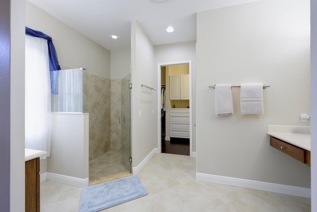 bathroom featuring tile floors, walk in shower, and vanity