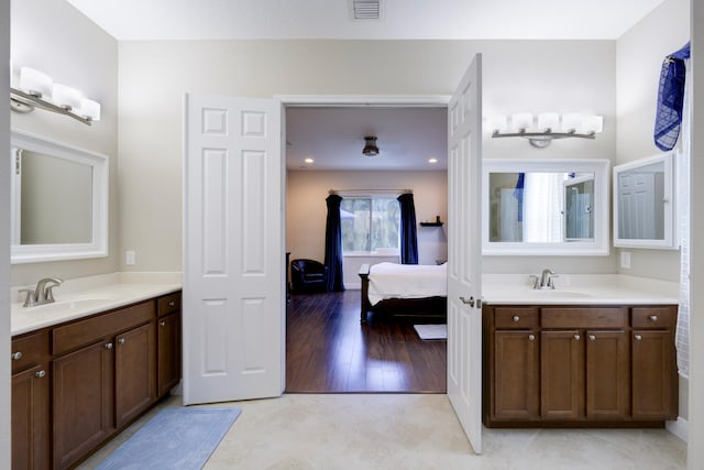 bathroom with hardwood / wood-style flooring and dual bowl vanity