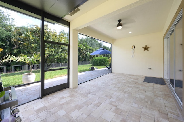 unfurnished sunroom with a healthy amount of sunlight and ceiling fan