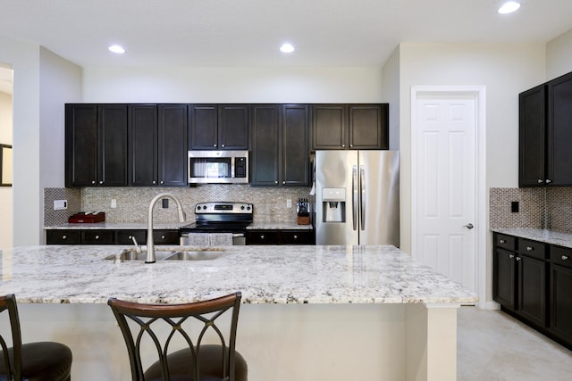 kitchen with sink, a kitchen bar, tasteful backsplash, and appliances with stainless steel finishes