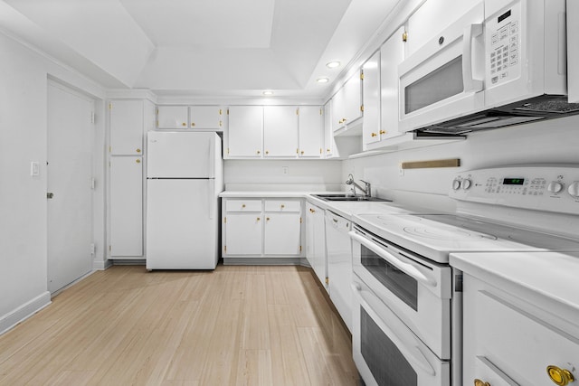 kitchen featuring sink, white cabinets, white appliances, and light wood-type flooring