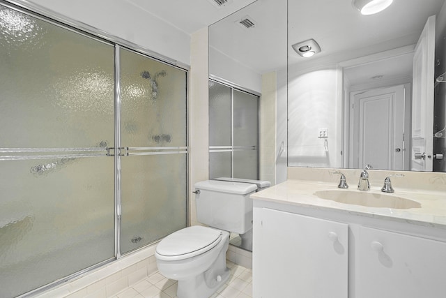 bathroom with tile patterned floors, vanity, toilet, and an enclosed shower