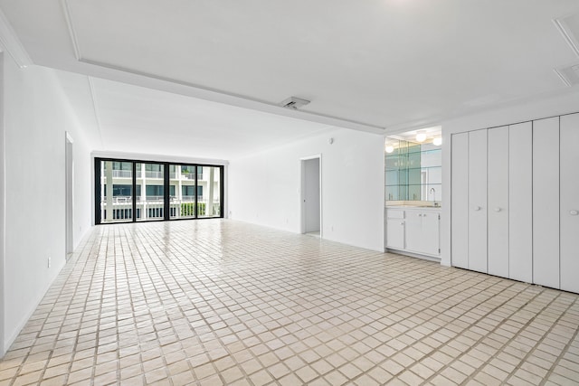 unfurnished living room featuring expansive windows and sink