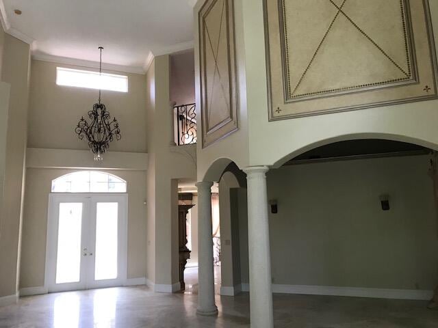 entrance foyer with ornate columns, crown molding, and french doors