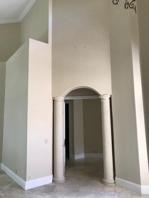 tiled empty room featuring decorative columns