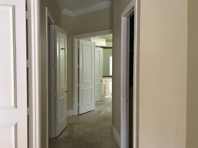 corridor with tile floors and crown molding