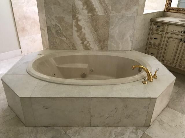 bathroom with tile flooring, vanity, and a tub