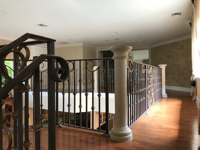 interior space featuring decorative columns, wood-type flooring, and crown molding