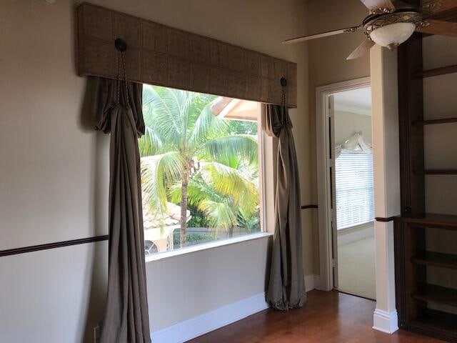 spare room with dark hardwood / wood-style floors, a wealth of natural light, and ceiling fan