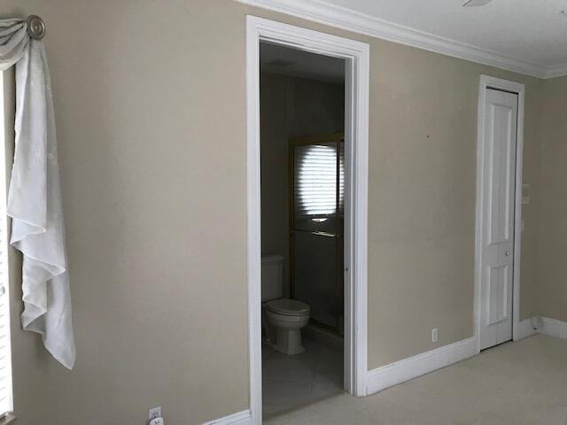 unfurnished bedroom featuring ornamental molding, carpet flooring, and ensuite bathroom