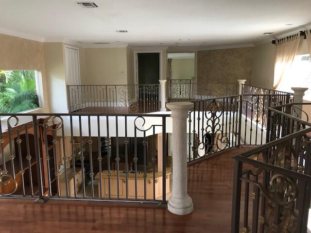 interior space featuring dark hardwood / wood-style floors, decorative columns, and ornamental molding