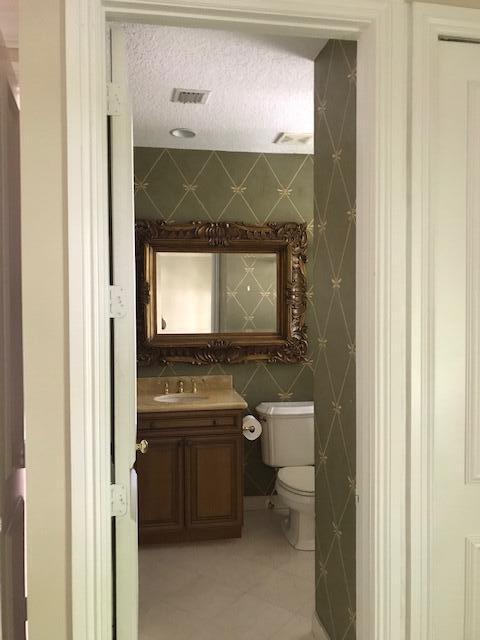 bathroom with tile flooring, tile walls, a textured ceiling, toilet, and vanity