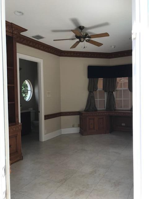 tiled spare room featuring ceiling fan