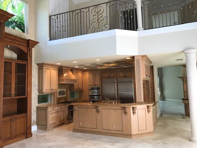 kitchen featuring appliances with stainless steel finishes, a towering ceiling, sink, decorative columns, and premium range hood