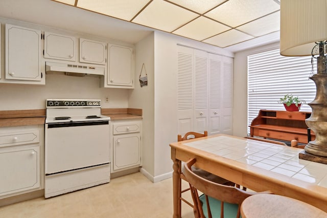 kitchen with tile countertops, baseboards, white range with electric stovetop, and under cabinet range hood