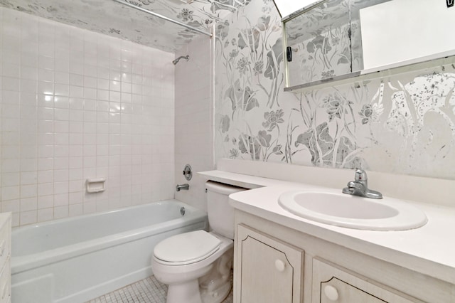 full bathroom with tile patterned flooring, tiled shower / bath combo, vanity, and toilet