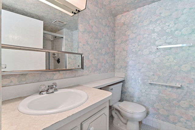 bathroom featuring visible vents, toilet, an enclosed shower, vanity, and wallpapered walls