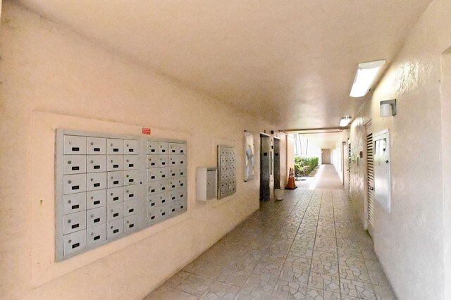 hallway featuring a mail area and elevator