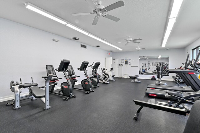 gym featuring baseboards, visible vents, and a textured ceiling