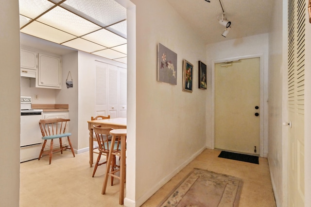 hallway with rail lighting and baseboards