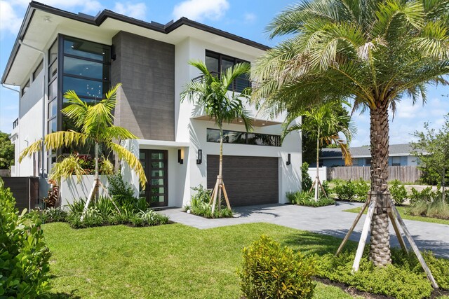 view of front of home featuring a garage, a balcony, a front yard, and french doors