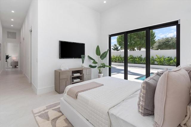 bedroom with access to outside, a high ceiling, and multiple windows