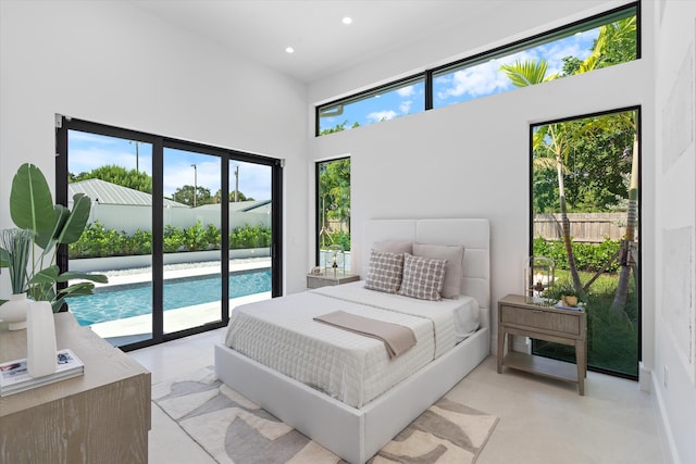 tiled bedroom featuring a high ceiling, access to outside, and multiple windows