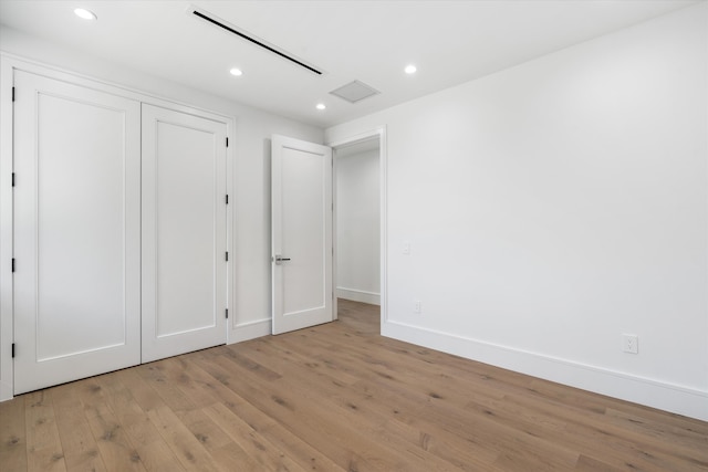 unfurnished bedroom featuring light wood-type flooring and a closet