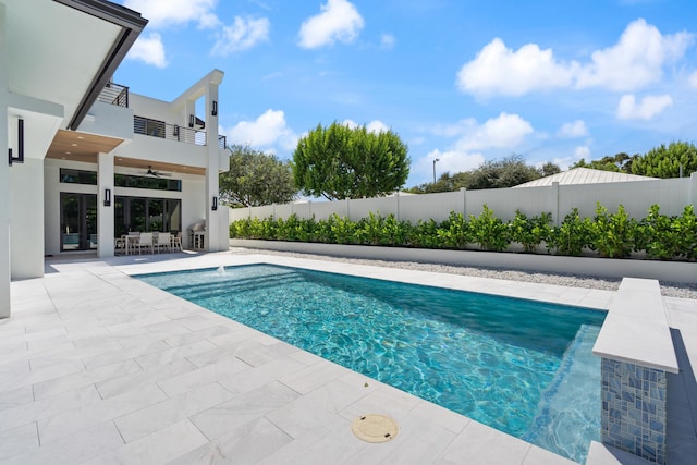 view of swimming pool featuring ceiling fan and a patio area