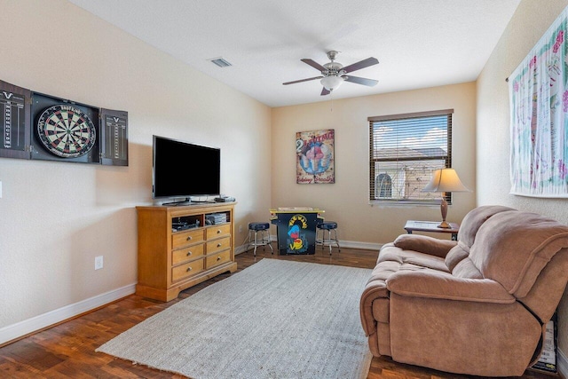 living room with ceiling fan and dark wood-type flooring