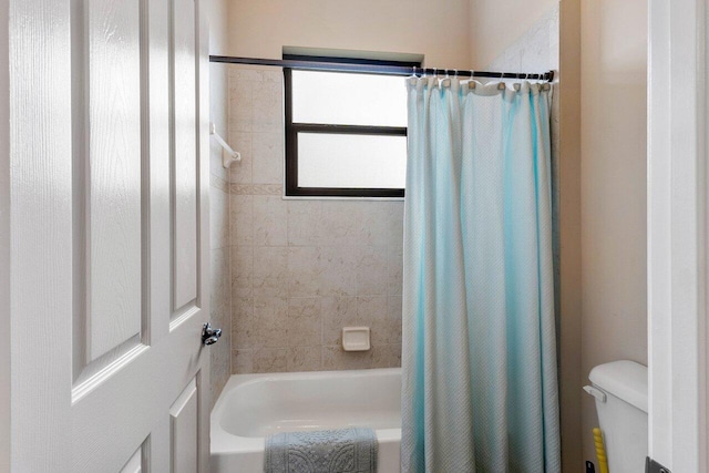 bathroom featuring shower / bath combo and toilet