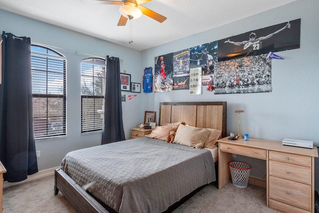 bedroom with a textured ceiling, ceiling fan, and light carpet