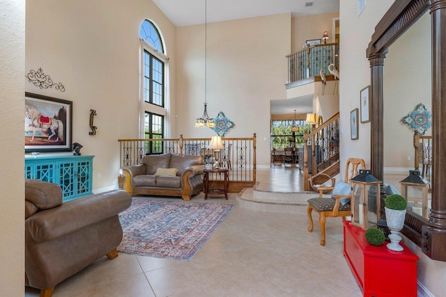 tiled living room with a notable chandelier, a healthy amount of sunlight, and a towering ceiling