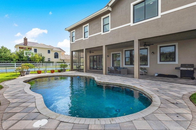 view of pool with ceiling fan, a grill, and a patio area